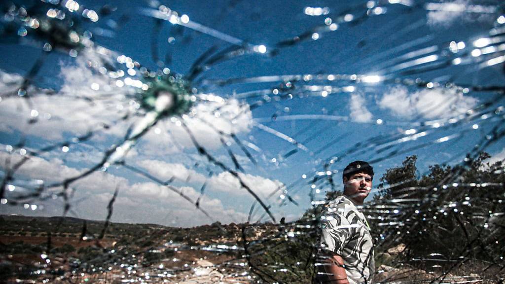 dpatopbilder - Ein Palästinenser inspiziert ein zerstörtes Auto, das von israelischen Streitkräften bei einer Razzia in der Nähe der Stadt Dschenin im nördlich besetzten Westjordanland bombardiert wurde. Foto: Nasser Ishtayeh/SOPA Images via ZUMA Press Wire/dpa