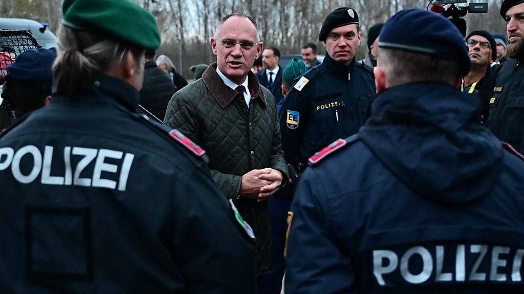 ARCHIV - Österreichs Innenminister Gerhard Karner (M) spricht mit österreichischen Polizisten bei einem Besuch an der ungarisch-serbischen Grenze in der Nähe des Dorfes Roszke, Ungarn. Foto: Marton Monus/-/dpa