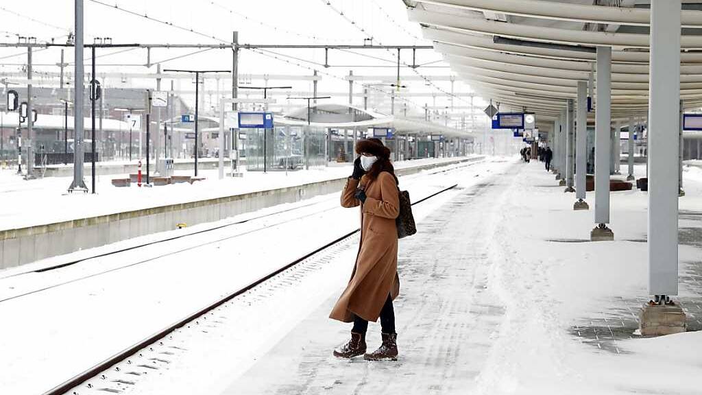 Eine Frau wartet auf dem Bahnsteig von Zwolle auf dem Zug. Schnee und Glätte behindern weiter das öffentliche Leben in den Niederlanden. Foto: Vincent Jannink/ANP/dpa