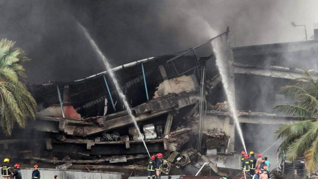 Nach einer Explosion in einer Verpackungsfabrik in Bangladesch kämpfen Feuerwehrleute gegen Feuer und Rauch.