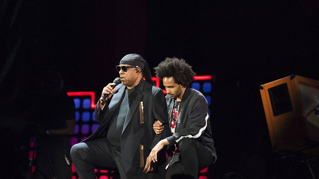 Stevie Wonder kniet gestützt von seinem Sohn auf der Bühne, um gegen US-Präsident Trump zu protestieren.