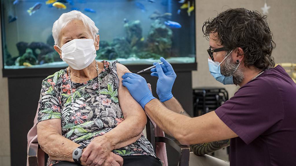 In einem Luzerner Pflegeheim lässt sich eine Frau gegen das Coronavirus impfen.