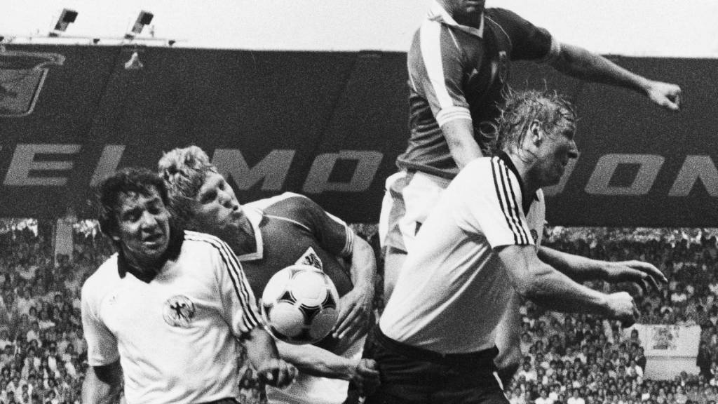 Die zwei Deutschen Felix Magath (links) und Horst Hrubesch in Gijon 1982 im Kampf um den Ball gegen die Österreicher Reinhold Hintermaier und Bruno Pezzey (in der Luft)