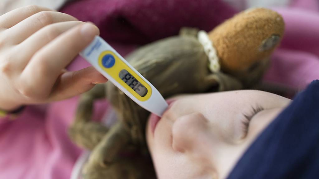 Ein Mädchen misst seine Körpertemperatur: Anhaltendes Fieber gehört zu den Symptomen des pädiatrischen entzündlichen Multisystem-Syndroms. (Symbolbild)