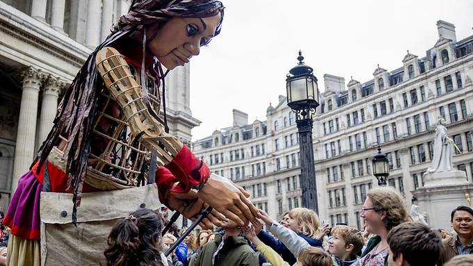 Menschenmenge begrüsst Flüchtlingspuppe an der St.-Pauls-Kathedrale