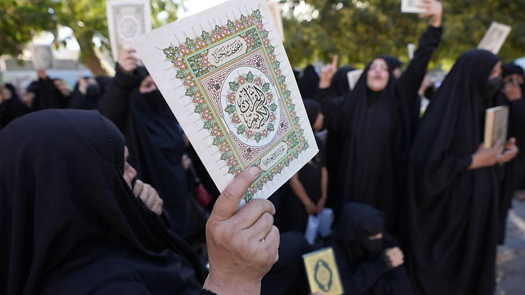 Irakische Frauen halten Kopien des Korans, des Heiligen Buches der Muslime, während einer Demonstration hoch. Foto: Hadi Mizban/AP/dpa