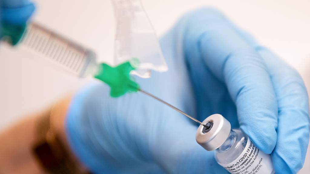 Eine Klinik-Mitarbeiterin zieht den Covid-19 Impfstoff von Biontech/Pfizer für eine Impfung auf eine Spritze. 