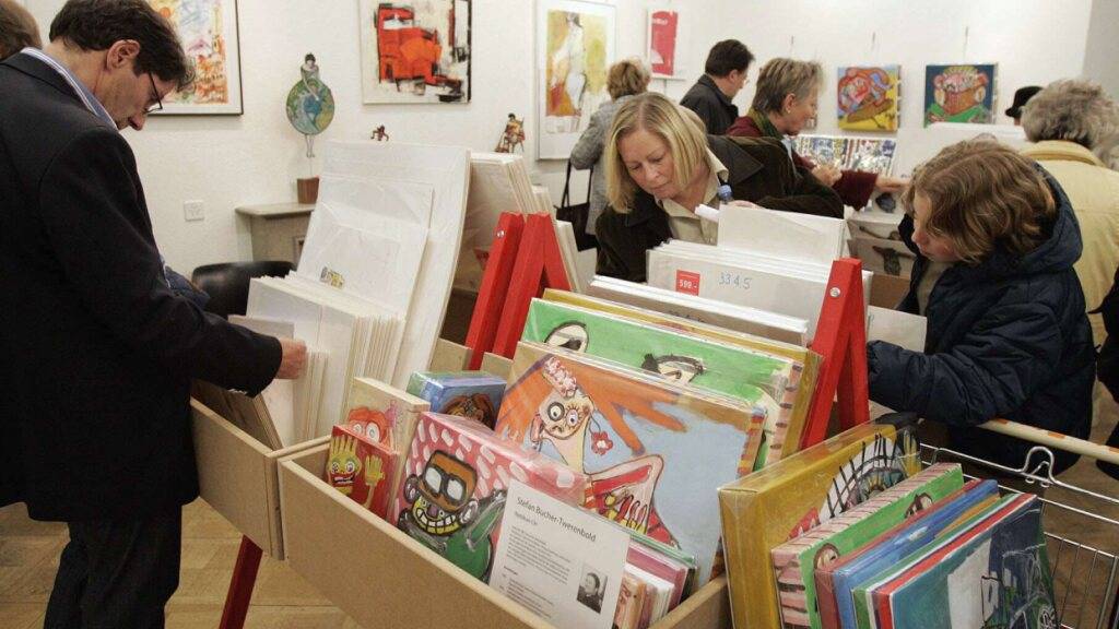 Besucherinnen und Besucher des Schweizer Kunstsupermarkts suchen sich Bilder für ihre Wohnstuben aus. Die Originale der Kunstschaffenden sind in vier Preiskategorien zu haben. Doch mit dem Ende der 25. Ausstellung am 12. Januar schliesst der Schweizer Kunstsupermarkt für immer. (Archivbild)