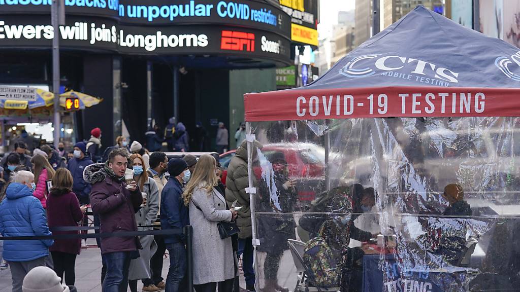 Menschen warten in einer Schlange vor einem Covid-Testzentrum am Times Square. Foto: Seth Wenig/AP/dpa