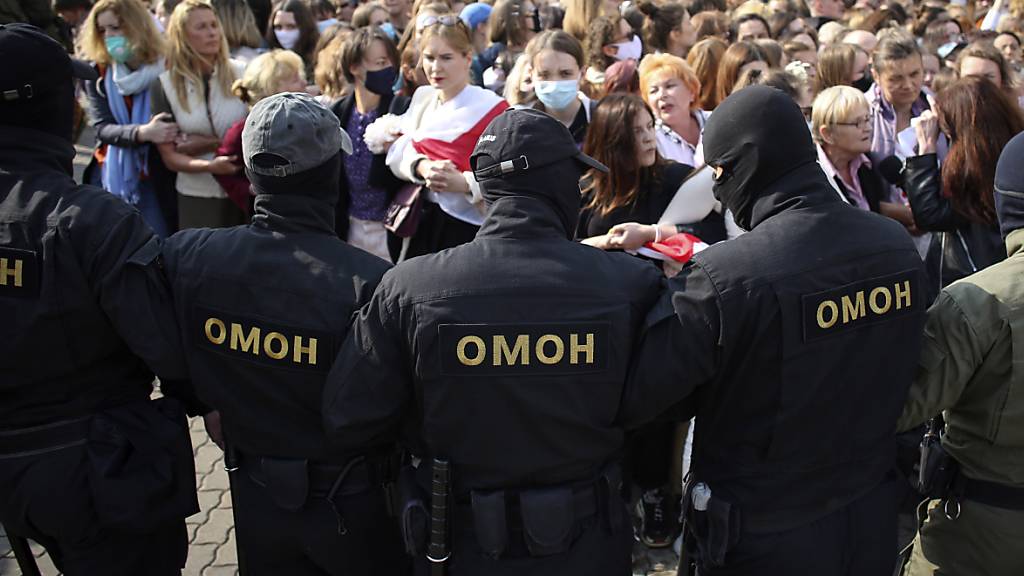 Polizisten der Spezialeinheit OMON stehen bei einem Protest gegen die Ergebnisse der belarussischen Präsidentenwahl vor den Demonstrantinnen. Foto: -/Tut.by via AP/dpa