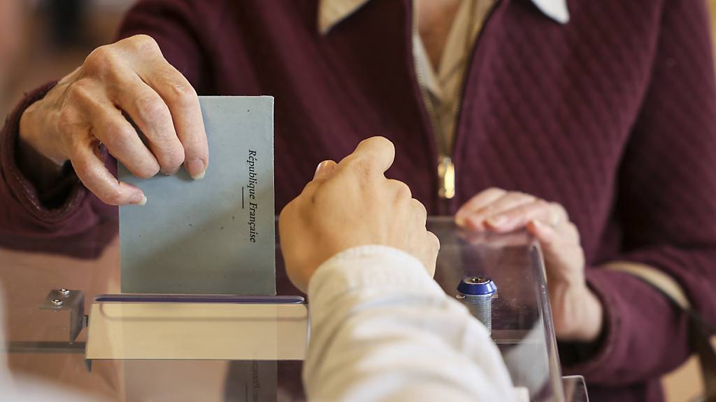 Eine Frau in Paris gibt ihre Stimme während der zweiten Runde der Parlamentswahlen ab. Foto: Thomas Padilla/AP/dpa