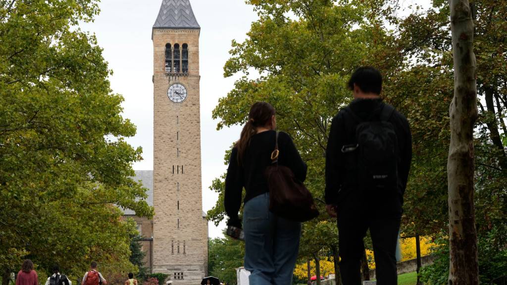 Fußgänger gehen auf dem Campus der Cornell University. Foto: Matt Rourke/AP/dpa