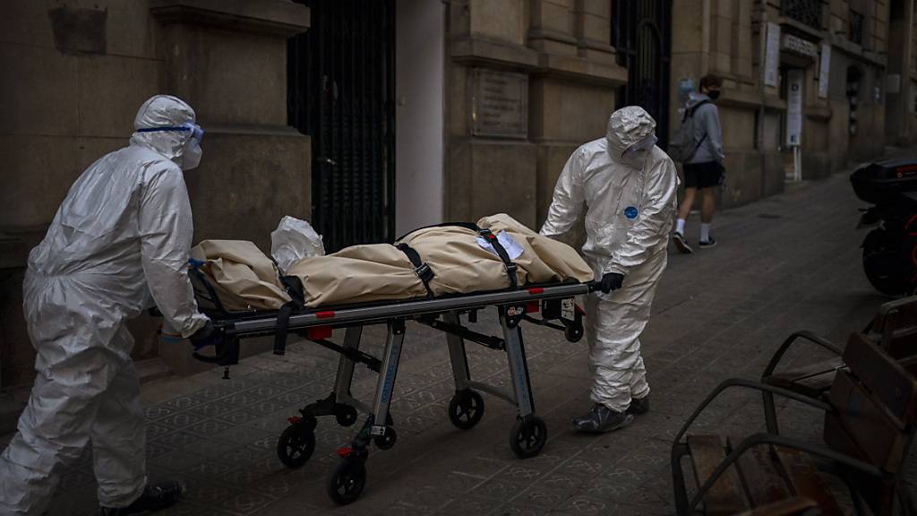 dpatopbilder - Leichenbestatter transportieren den Leichnam eines älteren Menschen, der in einem Pflegeheim an Covid-19 gestorben ist. Foto: Emilio Morenatti/AP/dpa