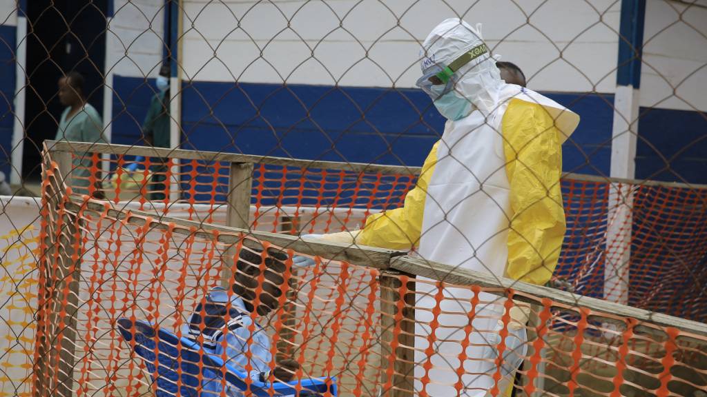 ARCHIV - ARCHIV. Ein Mitarbeiter des Gesundheitswesens spricht in einem Behandlungszentrum für Ebola-Patienten in der Provinz Nord-Kivu im Osten des Kongo mit einem Kind. Foto: Sebastien Kitsa Musayi/AP/dpa