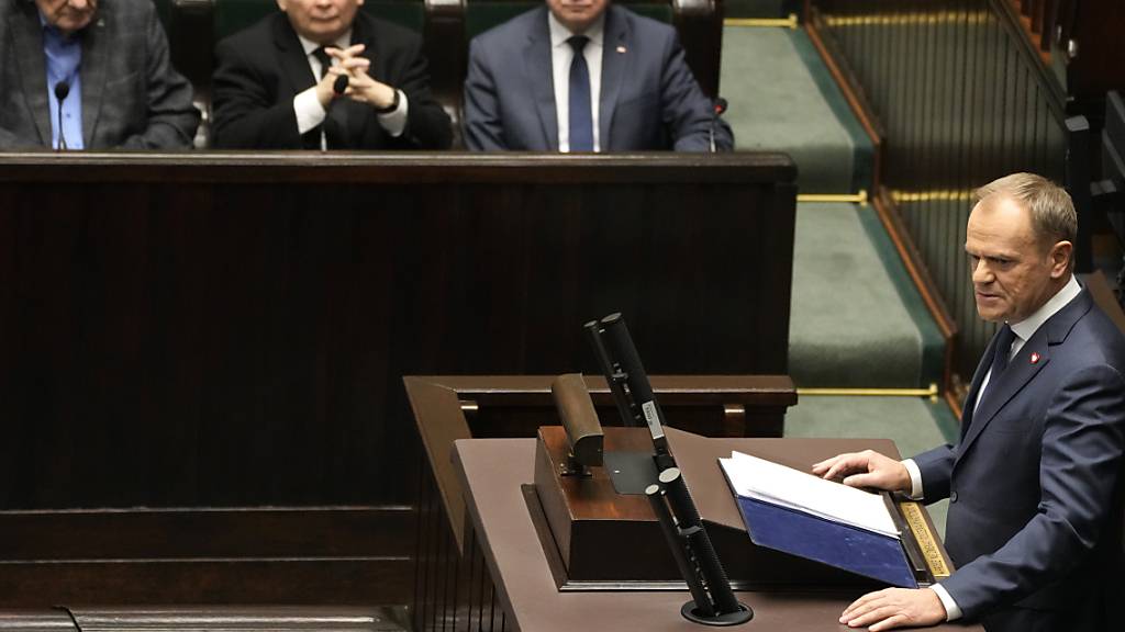 Donald Tusk (untren r), designierter neuer Ministerpräsident von Polen, spricht zu den Abgeordneten während seiner Rede im Parlament. Foto: Czarek Sokolowski/AP/dpa