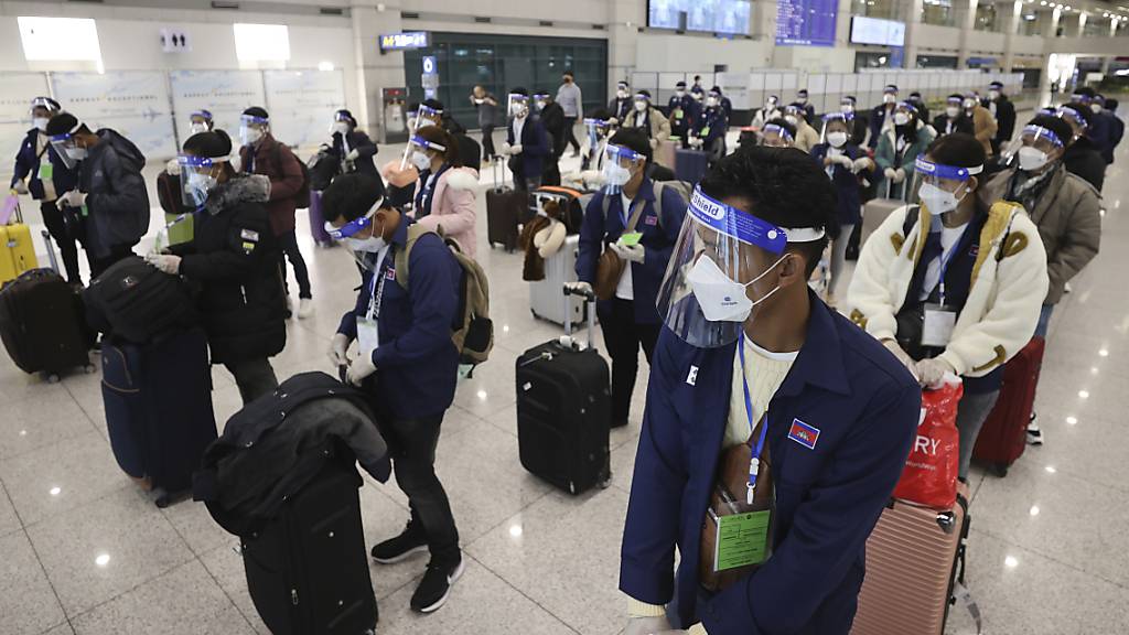 dpatopbilder - Passagiere, die aufgrund der Corona-Pandemie Mund-Nasen-Bedeckungen tragen, stehen nach ihrer Ankunft mit Abstand zueinander auf dem internationalen Flughafen Incheon. Foto: Lim Hwa-Young/Yonhap/AP/dpa