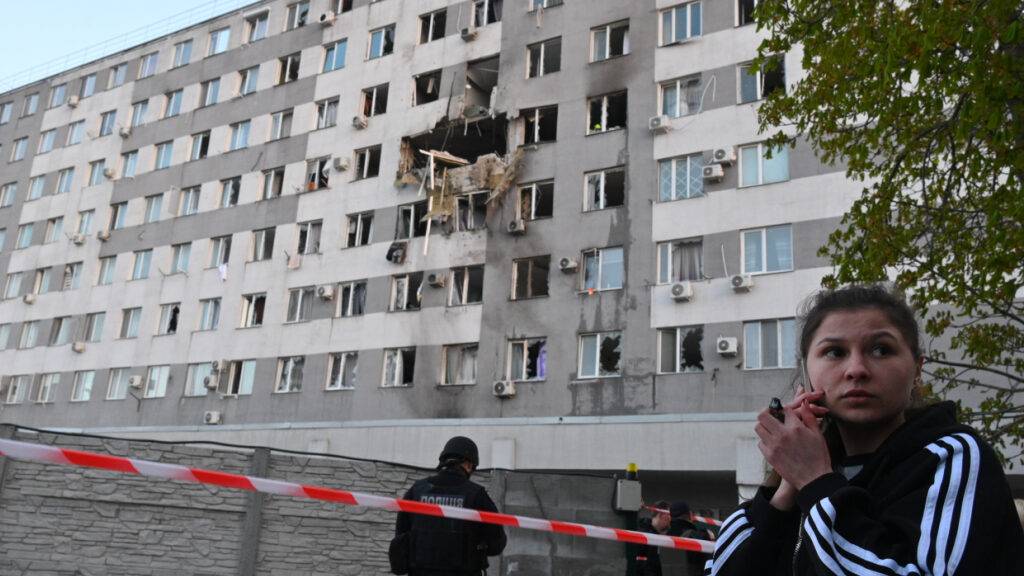 Eine Frau telefoniert vor einem Wohnhaus in Odessa, das nach einem russischen Drohnenangriff beschädigt wurde. Foto: Michael Shtekel/AP/dpa