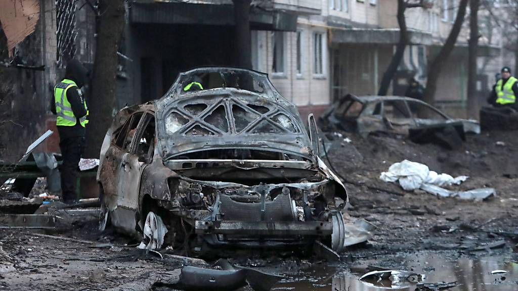 Ein durch herabfallende Raketentrümmer während eines russischen Raketenangriffs zerstörtes Auto steht vor einem Wohnhaus. Foto: ---/Ukrinform/dpa