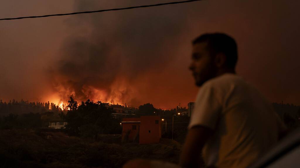 Anwohner versuchen ihre Häuser auf Teneriffa zu erreichen, während die Polizei das Gebiet abriegelt. Foto: Arturo Rodriguez/AP/dpa