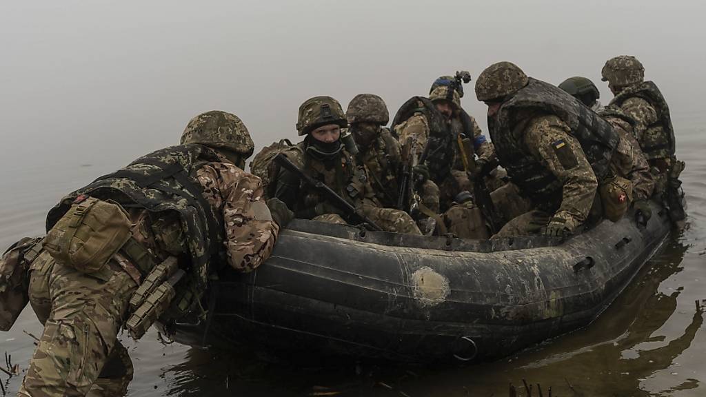 Ukrainische Marinesoldaten sitzen in einem Boot im Dnepr an der Frontlinie bei Cherson. Foto: Alex Babenko/AP/dpa