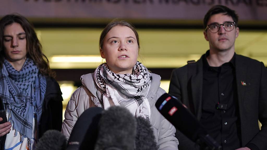 dpatopbilder - Greta Thunberg (M), Klimaaktivistin aus Schweden, lacht und streckt eine Hand aus, als sie vor dem Westminster Magistrates Court eintrifft.  In London wurde der Prozess gegen die schwedische Klimaaktivistin Greta Thunberg eingestellt. Foto: Alberto Pezzali/AP/dpa