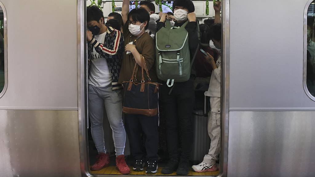 Pendler drängen sich in Tokio in einen Zugwaggon, nachdem ein starkes Erdbeben in der Nacht zum Donnerstag (Ortszeit) die Region Tokio erschüttert und Züge und U-Bahnen vorübergehend lahmgelegt hat. Bei dem Erdbeben sind laut Berichten japanischer Medien mindestens 32 Menschen verletzt worden. Foto: Kiichiro Sato/AP/dpa