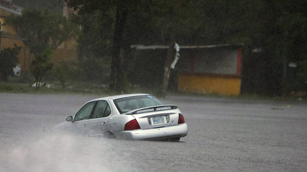 Ein Auto steckt in einer von Hurrikan «Rick» überfluteten Straße. Der Hurrikan hatte Windgeschwindigkeiten von um die 165 Kilometer pro Stunde in sich, als er auf Festland nahe dem Ort La Unión im südlichen Bundesstaat Guerrero traf. Foto: Armando Solis/AP/dpa