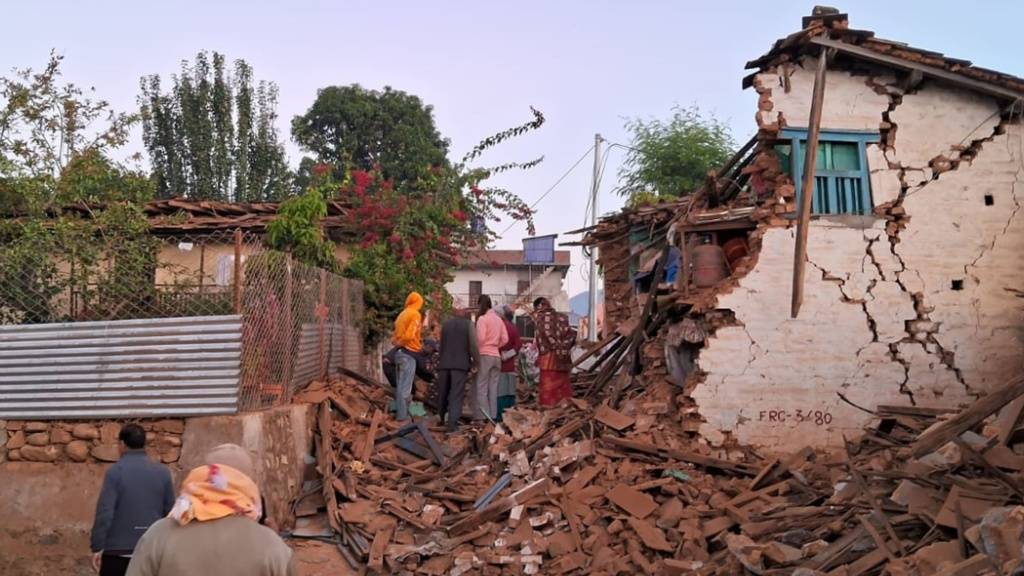 HANDOUT - Menschen suchen in den Trümmern nach ihren Habseligkeiten. Foto: Sunil Sharma/ZUMA Press Wire/dpa
