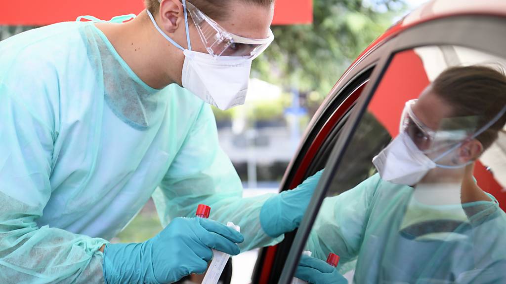 Ein Gesundheitsmitarbeiter in Yverdon-les-Bains VD sammelt in einem Coronavirus-Testzentrum einen Mundabstrich ein. (Archivbild)