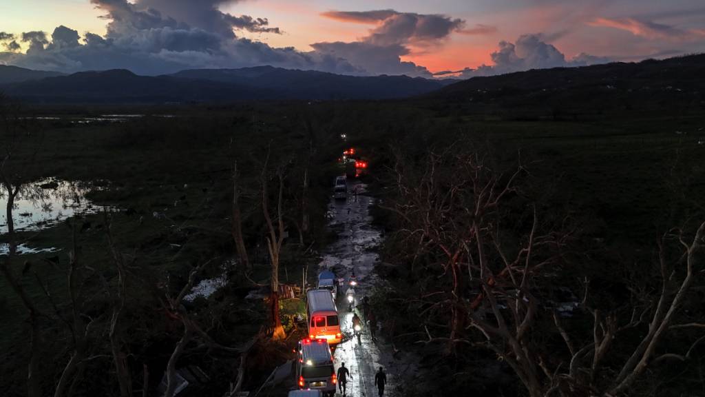 Ein Konvoi mit Hilfsgütern für Black River, das von Hurrikan «Melissa» heimgesucht wurde, fährt durch Holland Bamboo, wo umgestürzte Bäume und Trümmer die Straße teilweise blockieren. Foto: Matias Delacroix/AP/dpa