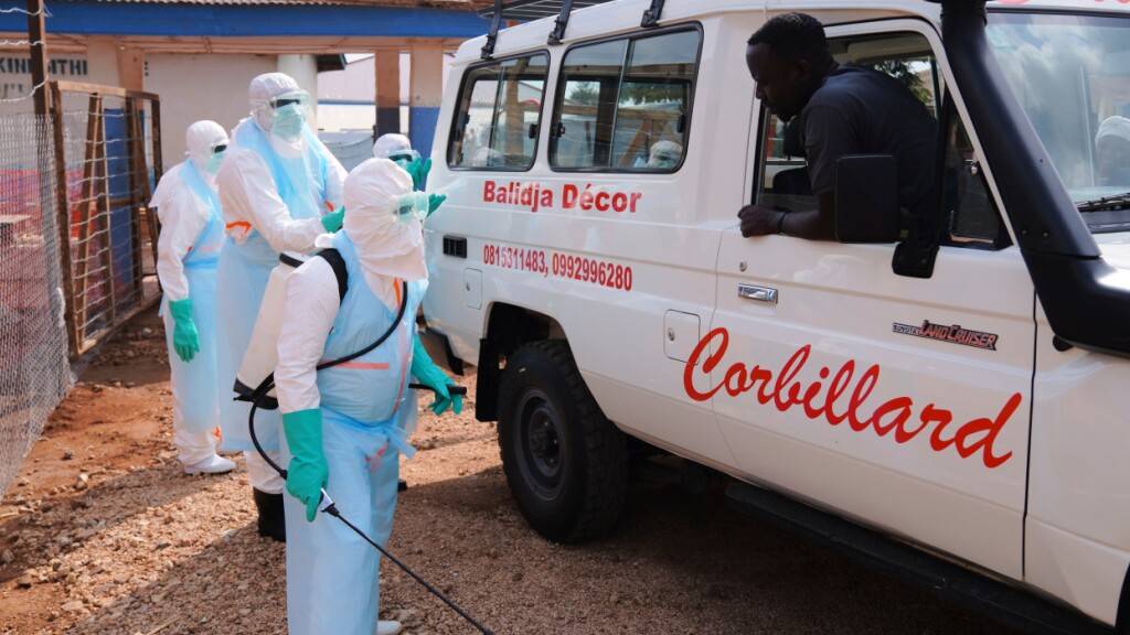 ARCHIV - Medizinisches Personal desinfiziert einen Krankenwagen im Ebola-Behandlungszentrum in Bunia. Foto: Dirole Lotsima Dieudonne/AP/dpa