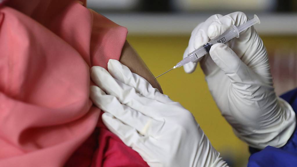 Eine Frau erhält bei einer Massenimpfung in Jakarta eine Spritze mit Impfstoff gegen das Coronavirus.