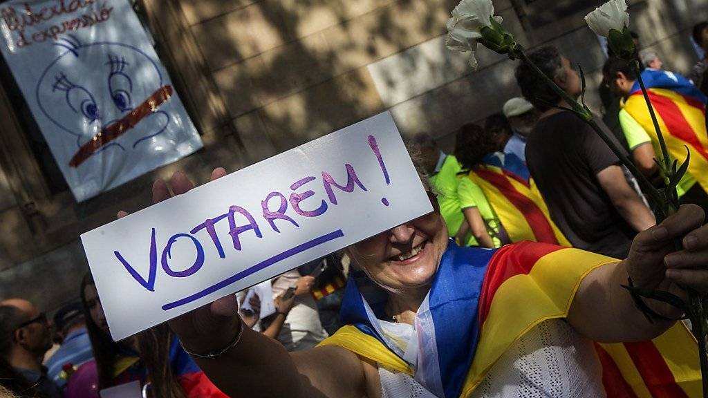 «Wir werden wählen» steht auf dem Schild dieser Demonstrantin in Barcelona. Damit dies geschehen kann, haben katalanische Separatisten Wahlzettel verteilt.