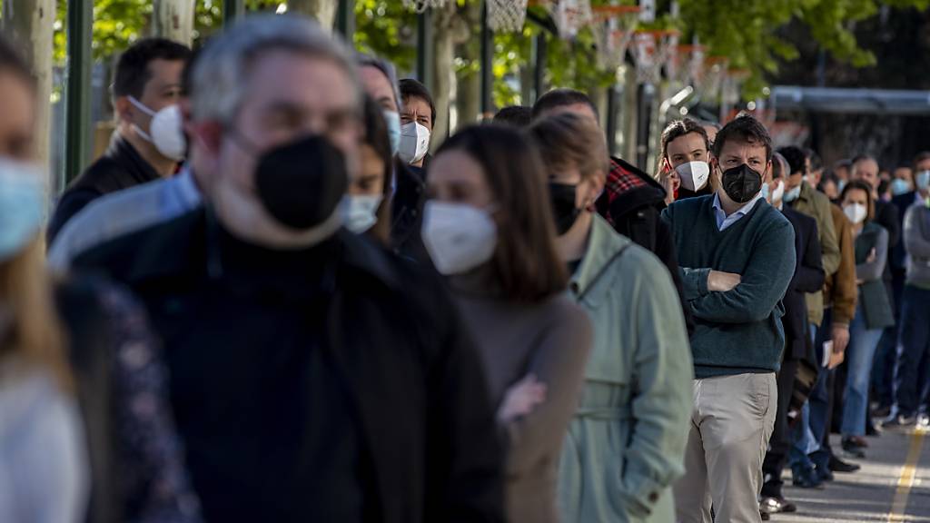 Menschen stehen Schlange, um ihre Stimme während der Regionalwahlen in Madrid abzugeben. Foto: Manu Fernandez/AP/dpa