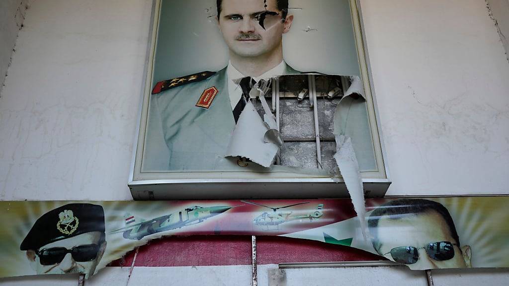 dpatopbilder - Ein zerrissenes Plakat zeigt den gestürzten syrischen Präsidenten Baschar al-Assad am Eingang eines Gefängnisses in Damaskus. Foto: Hussein Malla/AP/dpa