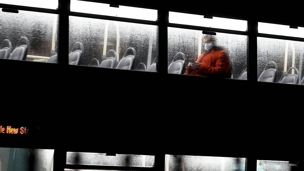 dpatopbilder - Ein Mann fährt in Liverpool in einem Doppeldecker-Bus und trägt einen Mund-Nasen-Schutz. Nach Ansicht von Jeffrey Barrett vom Wellcome-Sanger-Institut wird die Omikron-Variante des Coronavirus in Großbritannien innerhalb von Wochen dominant werden. Das sagte er dem BBC-Radio am Dienstag. Foto: Peter Byrne/PA/dpa