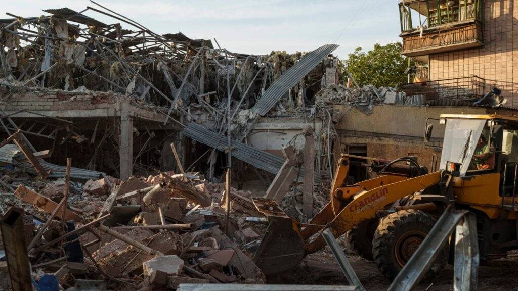 ARCHIV - Ein Traktor beseitigt die Trümmer nach einem russischen Angriff auf das Hotel Sapphire. Foto: Evgeniy Maloletka/AP/dpa