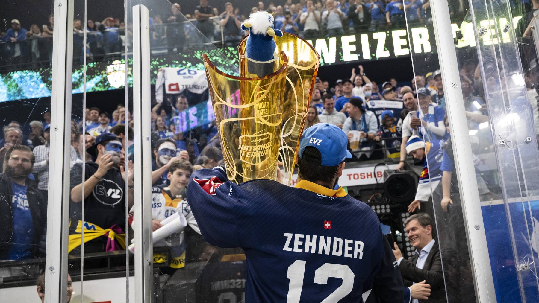 Zugs Yannick Zehnder jubelt mit dem Pokal nach ihrem Sieg im siebten Playoff-Final Eishockeyspiel der National League zwischen dem EV Zug und ZSC Lions am Sonntag, 1. Mai 2022, in der Bossard Arena in Zug.