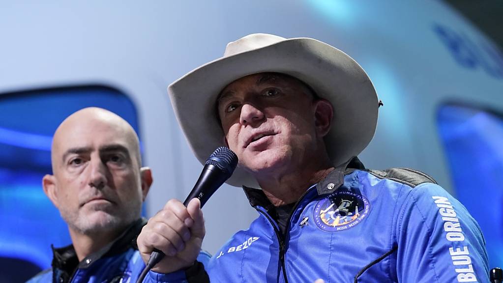 Jeff Bezos (r), Gründer von Amazon und des Weltraumtourismus-Unternehmens Blue Origin, und sein Bruder Mark Bezos sprechen bei einer Pressekonferenz. Blue Origin plant eine eigene Station im All mit dem Namen «Orbital Reef». Das teilte die Firma Blue Origin am Montag mit.