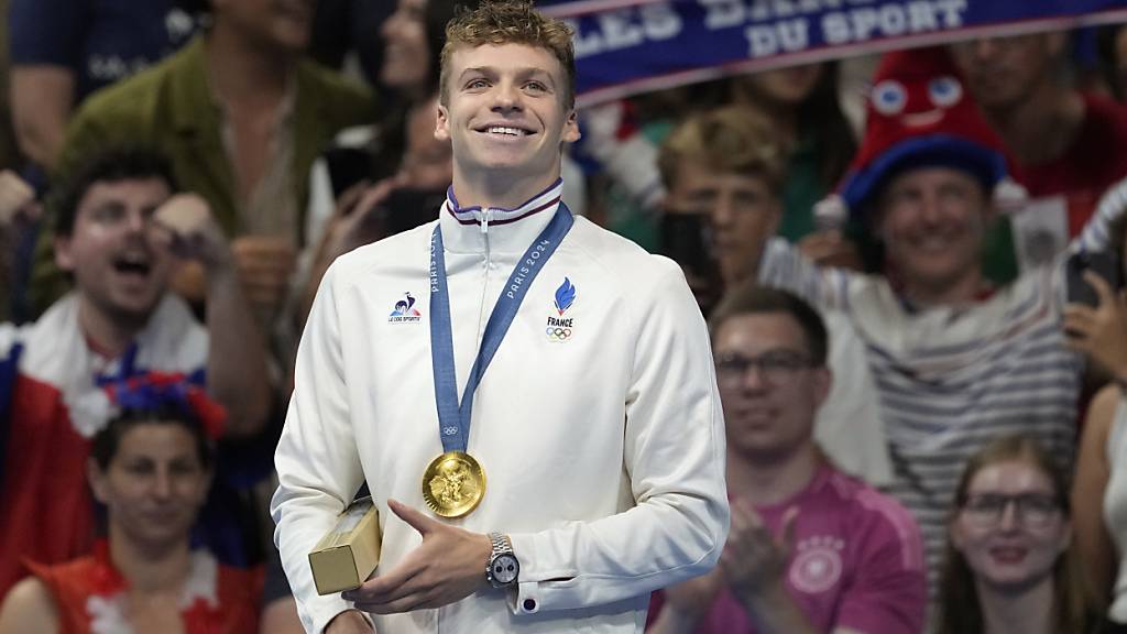 Léon Marchand posiert auf dem Podest nach dem Gewinn von Olympia-Gold über 200 m Lagen