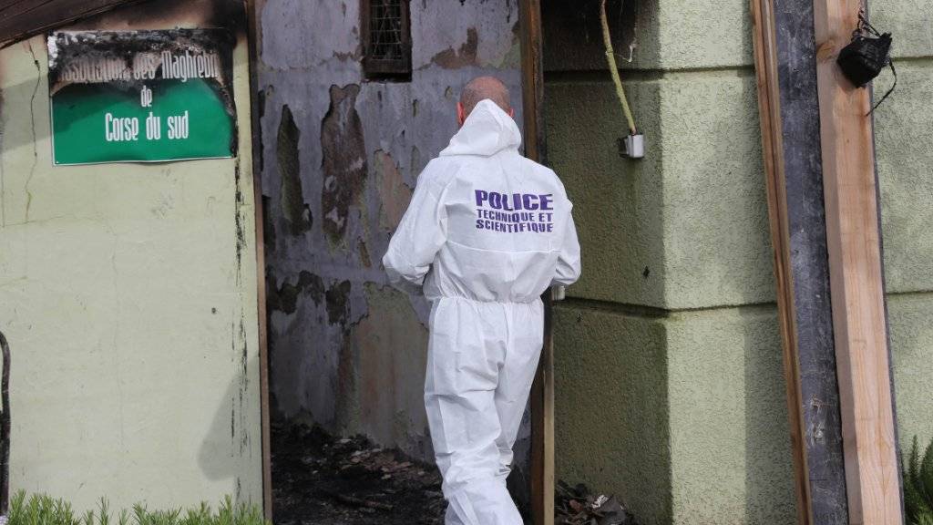 Ein Polizist untersucht den vom Feuer beschädigten Gebetsraum in der korsischen Stadt Ajaccio.