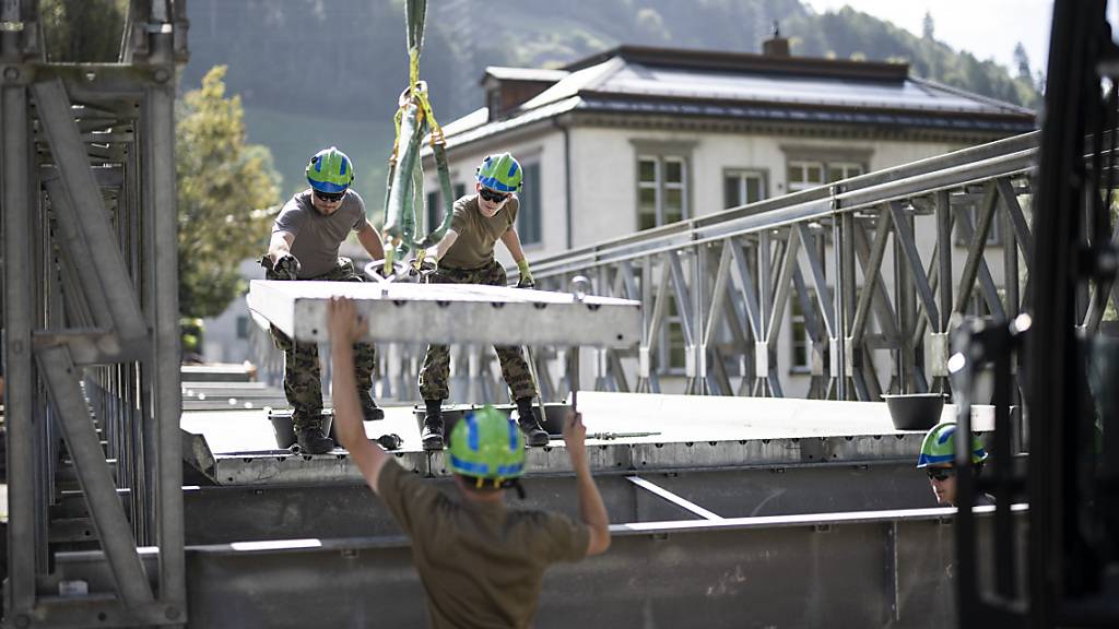 Die Notbrücke ermöglicht den Zugang ins betroffene Gebiet: Wehrleute beim Bau in Schwanden GL.