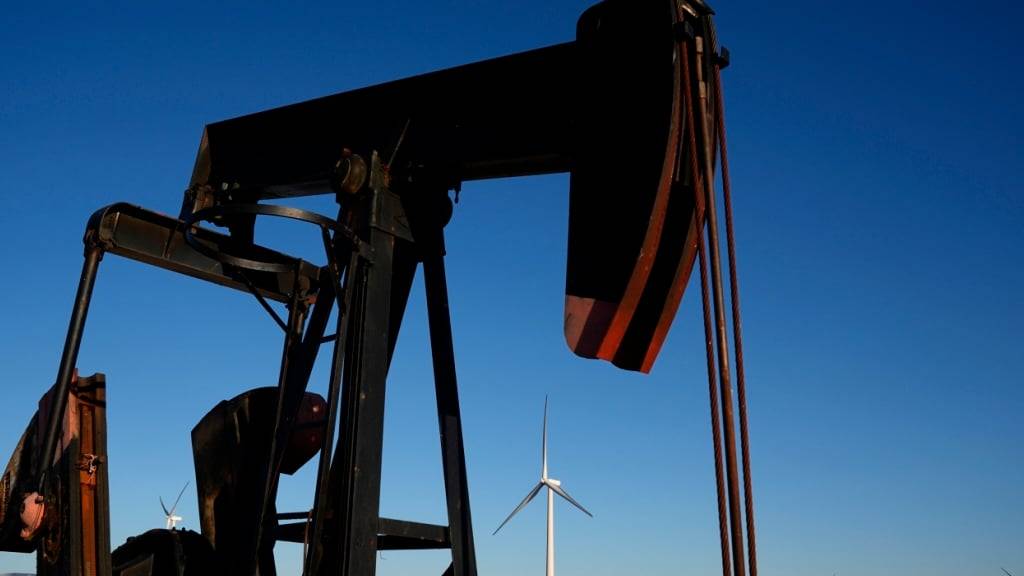 ARCHIV - Eine Tiefpumpe arbeitet im Vordergrund, während sich in der Ferne die Windturbinen des Buckeye Wind Energy Windparks erheben. Auf der Klimakonferenz in Brasilien sind auch viele Öl-Lobbyisten akkreditiert. Foto: Charlie Riedel/AP/dpa