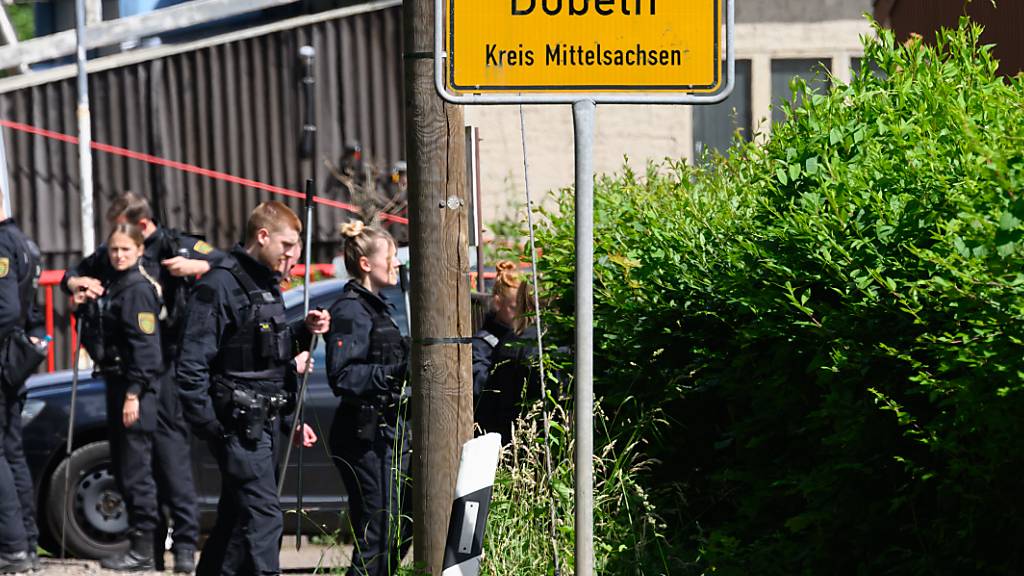Polizisten sind mit Suchstangen auf der Erkundung nach einer vermissten Grundschülerin auf einem Firmengelände unterwegs. Foto: Robert Michael/dpa