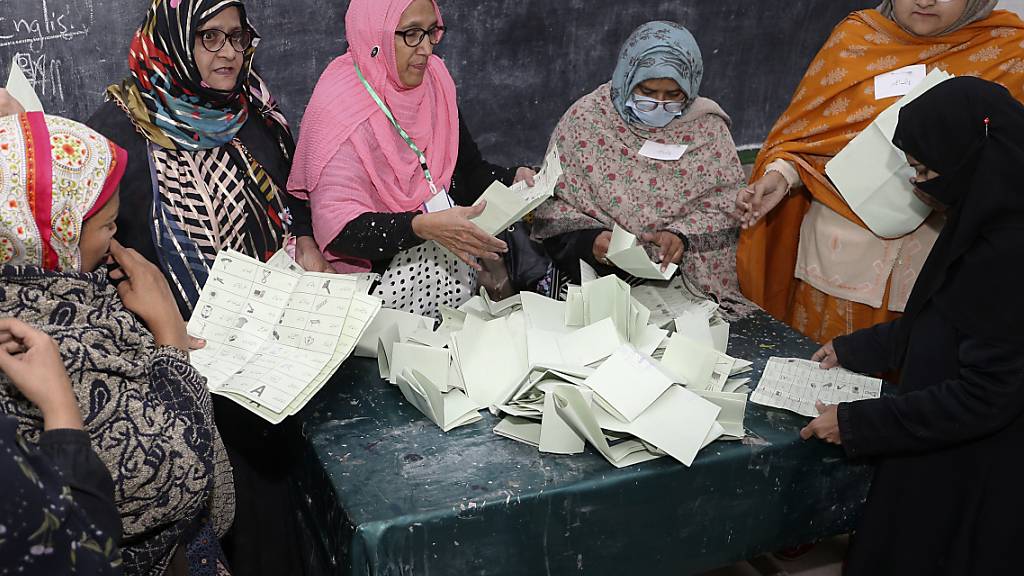 Mitglieder des Wahlpersonals während der Auszählung der Stimmen nach Schließung der Wahllokale für die Parlamentswahlen. Foto: Pervez Masih/AP/dpa