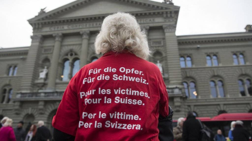 Eine Betroffene posiert mit einem T-Shirt mit der Aufschrift «Für die Opfer. Für die Schweiz.» bei der Einreichung der Unterschriften für die Wiedergutmachungsinitiative am 19. Dezember 2014 in Bern. (Archivbild)