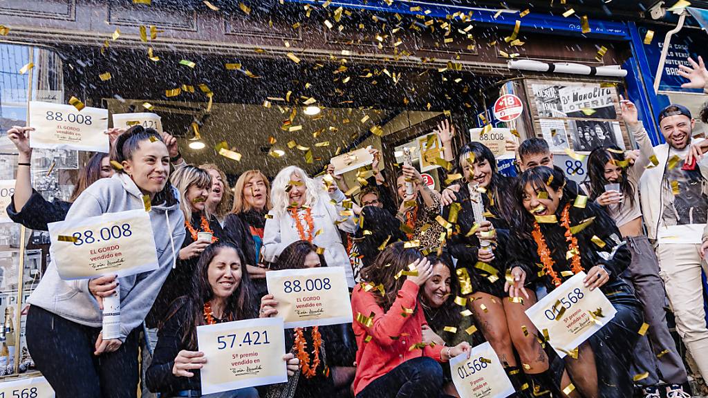 Die Gewinner des ersten Preises der Weihnachtslotterie 2023 mit der Nummer 88008 feiern ihr Glück in Dona Manolita, Madrid. Foto: Carlos Luján/EUROPA PRESS/dpa