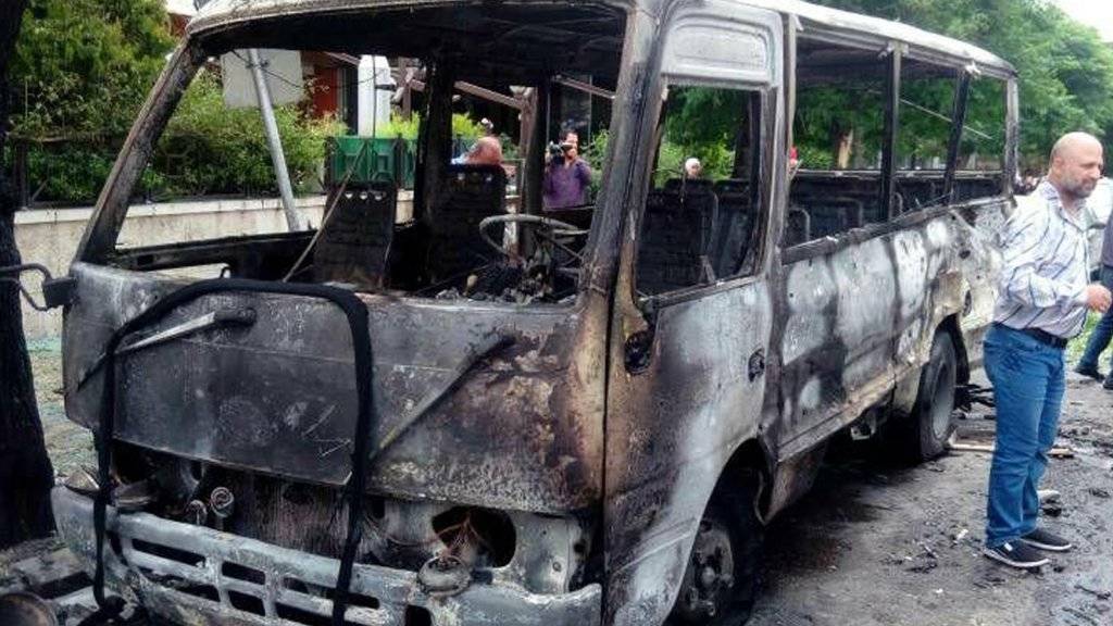 Bilder der staatlichen syrischen Nachrichtenagentur SANA zeigen einen ausgebrannten Bus: Das Fahrzeug ist gemäss den Angaben von Granaten getroffen worden.