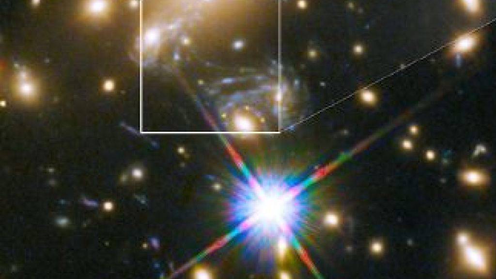 In rund fünf Milliarden Lichtjahren Entfernung von der Erde dient eine Ansammlung von Galaxien als Gravitationslinse. Dies lässt den Stern Ikarus sichtbar werden, der neun Milliarden Lichtjahre entfernt ist.