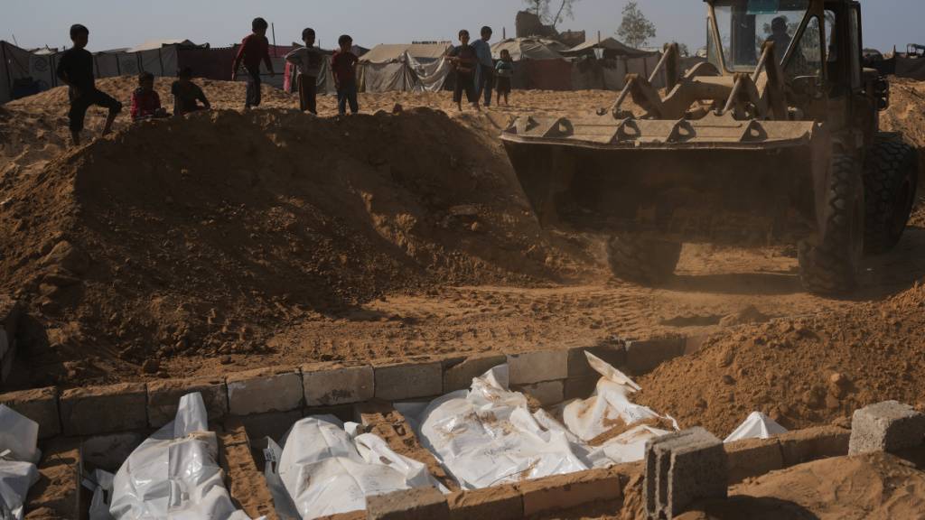 Die Leichen nicht identifizierter Palästinenser, die im Rahmen des Waffenstillstandsabkommens aus Israel zurückgebracht wurden, werden in einem Massengrab in Deir al-Balah im Gazastreifen begraben, Mittwoch, 5. November 2025. Foto: Abdel Kareem Hana/AP/dpa